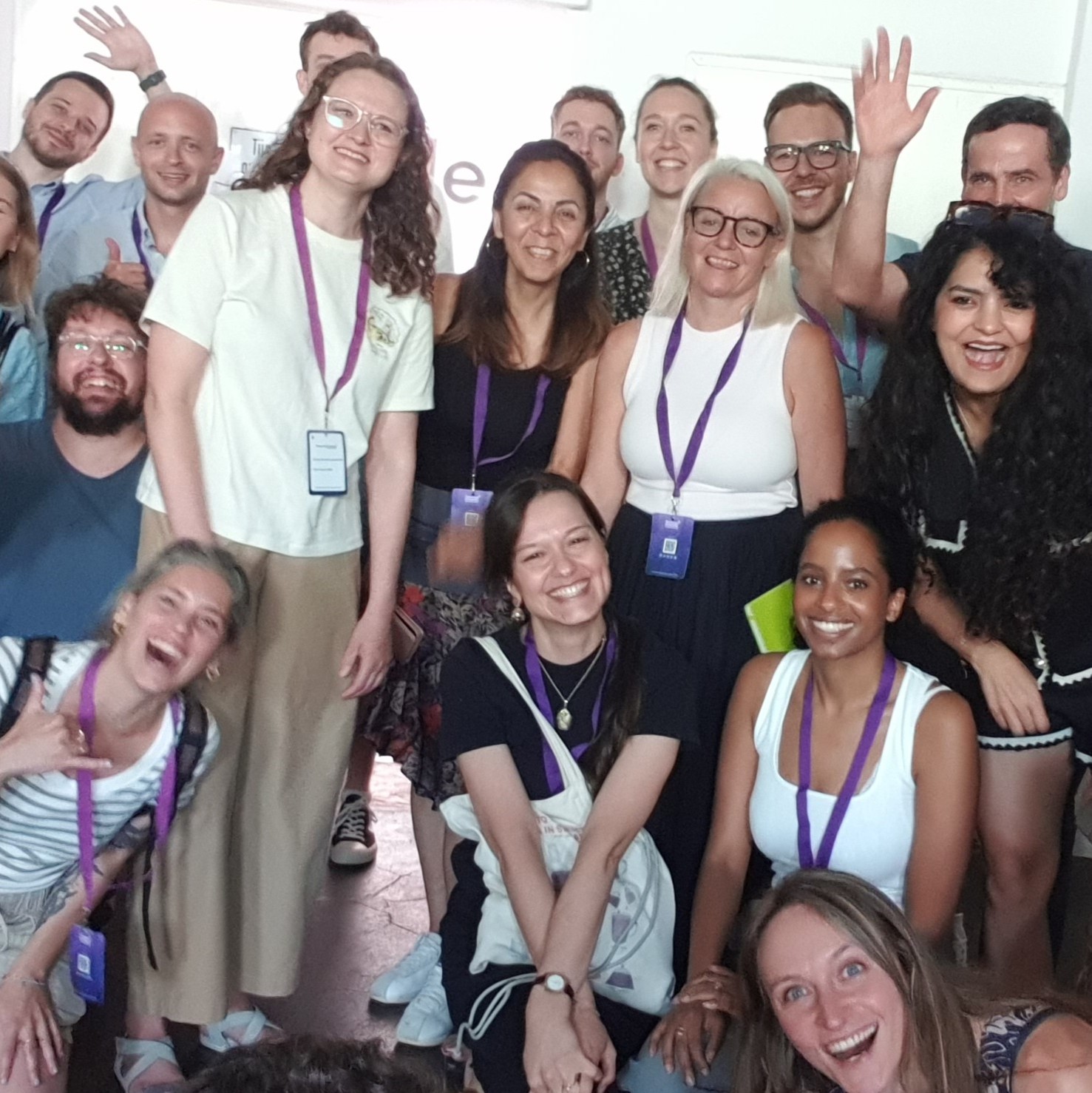 A lively group of Next Chapter Collective members smiling and waving together